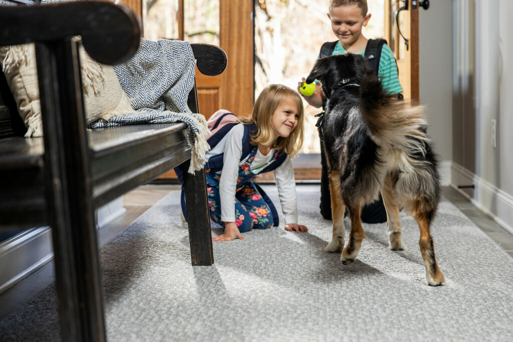 Kids plying with dog on carpet flooring | Chesapeake Family Flooring